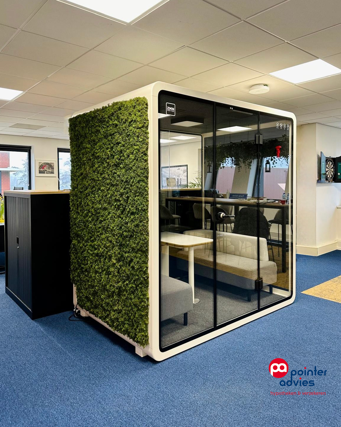 Two men standing outdoors leaning on a metal rail in front of a building entrance.