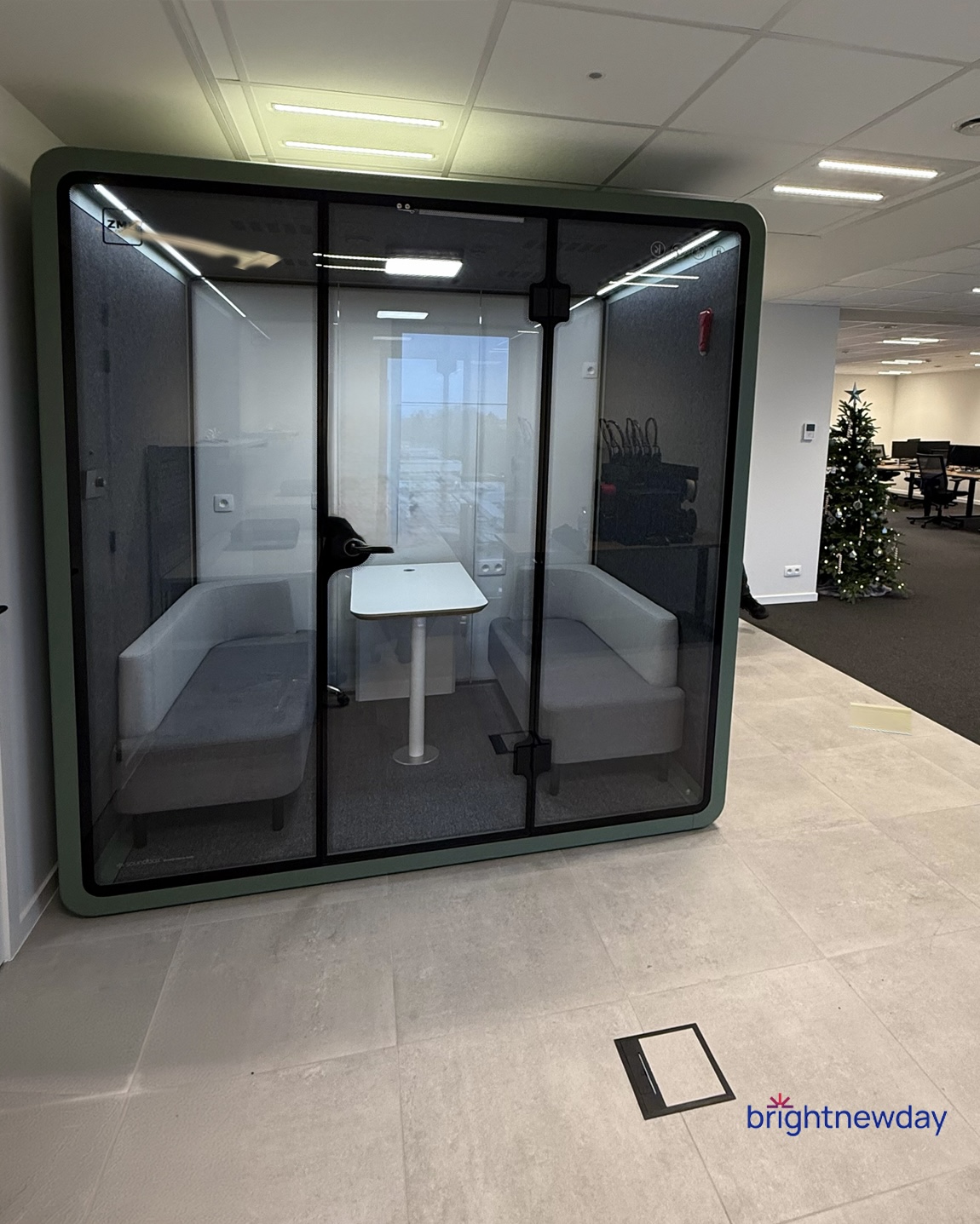 Two men standing outdoors leaning on a metal rail in front of a building entrance.