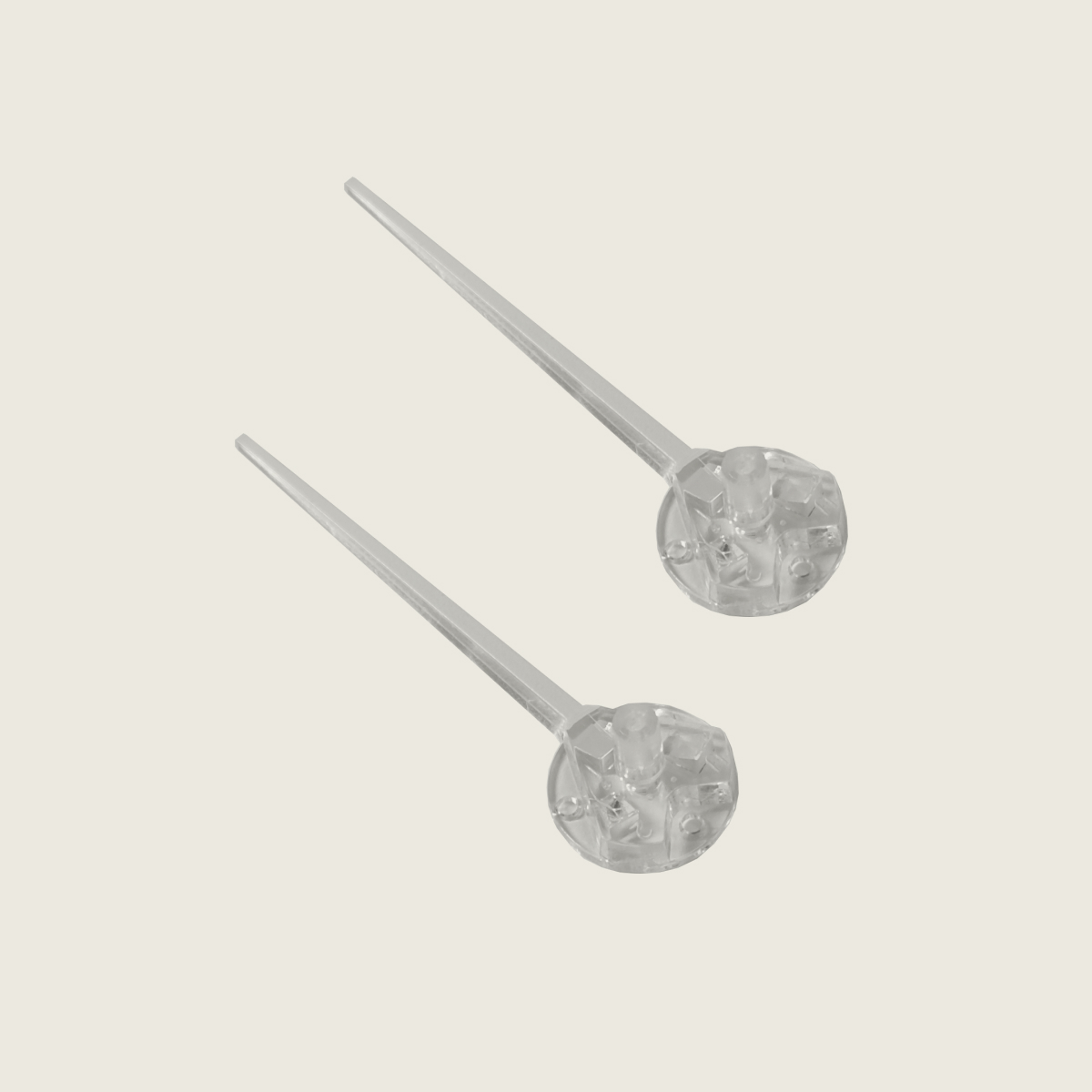 Two transparent plastic injection molded components with a circular base and elongated tapered shaft.