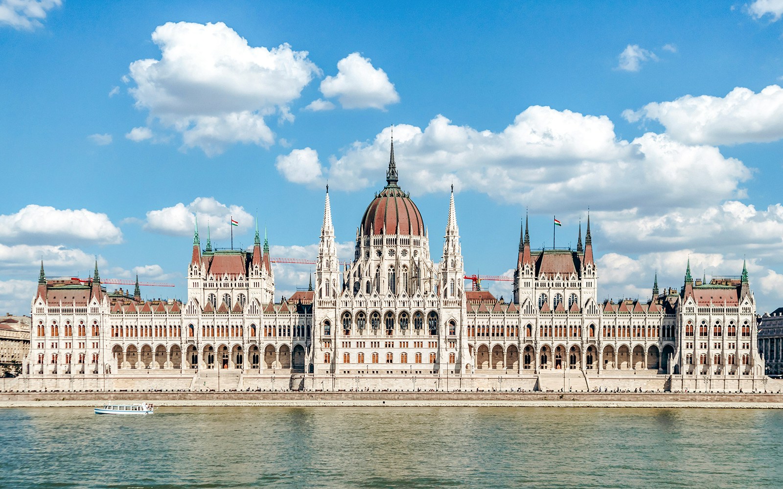 Colorful autumn trees in a park with the Chain Bridge and Hungarian Parliament building across the Danube River in Budapest.