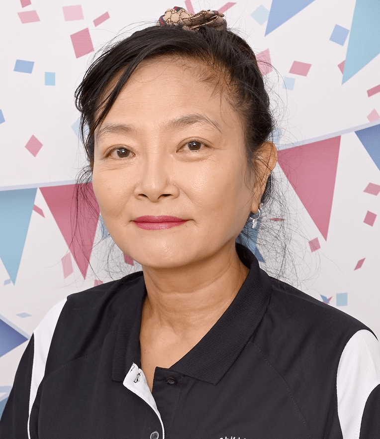 Portrait of Miss Linda Director, ECT wearing a black and white collared shirt, with a festive background of colorful triangular flags and confetti.