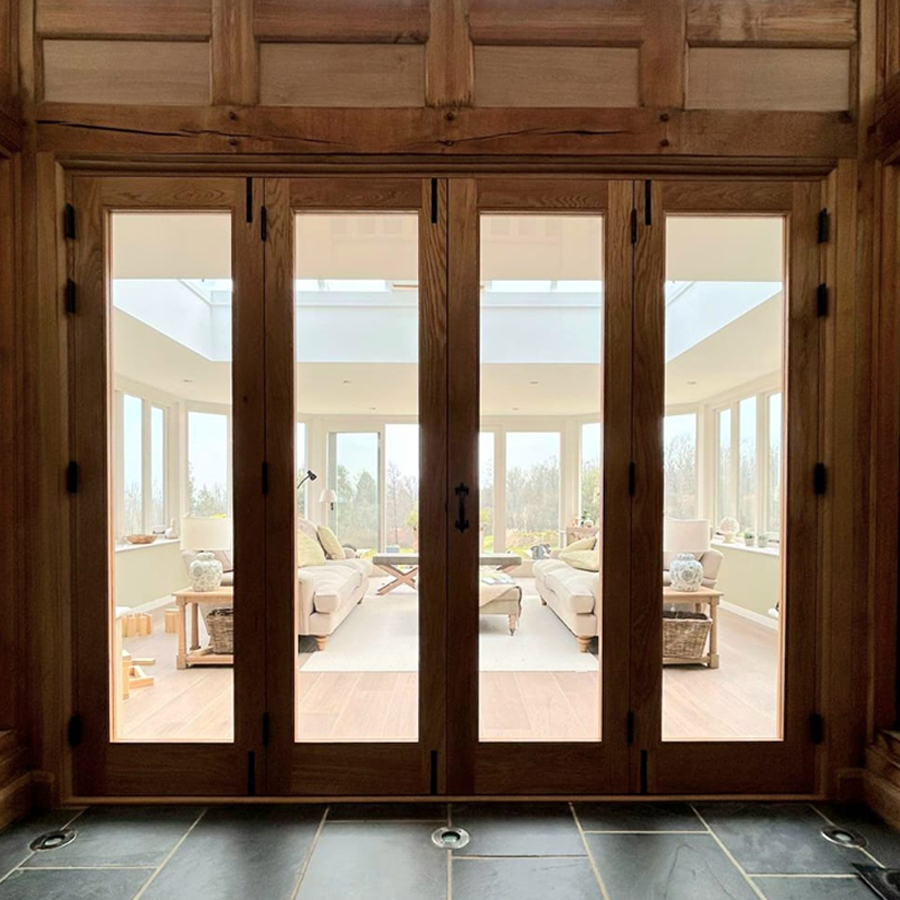 Four doors made of warm wood frames around glass. Designed and created by RGM Joinery