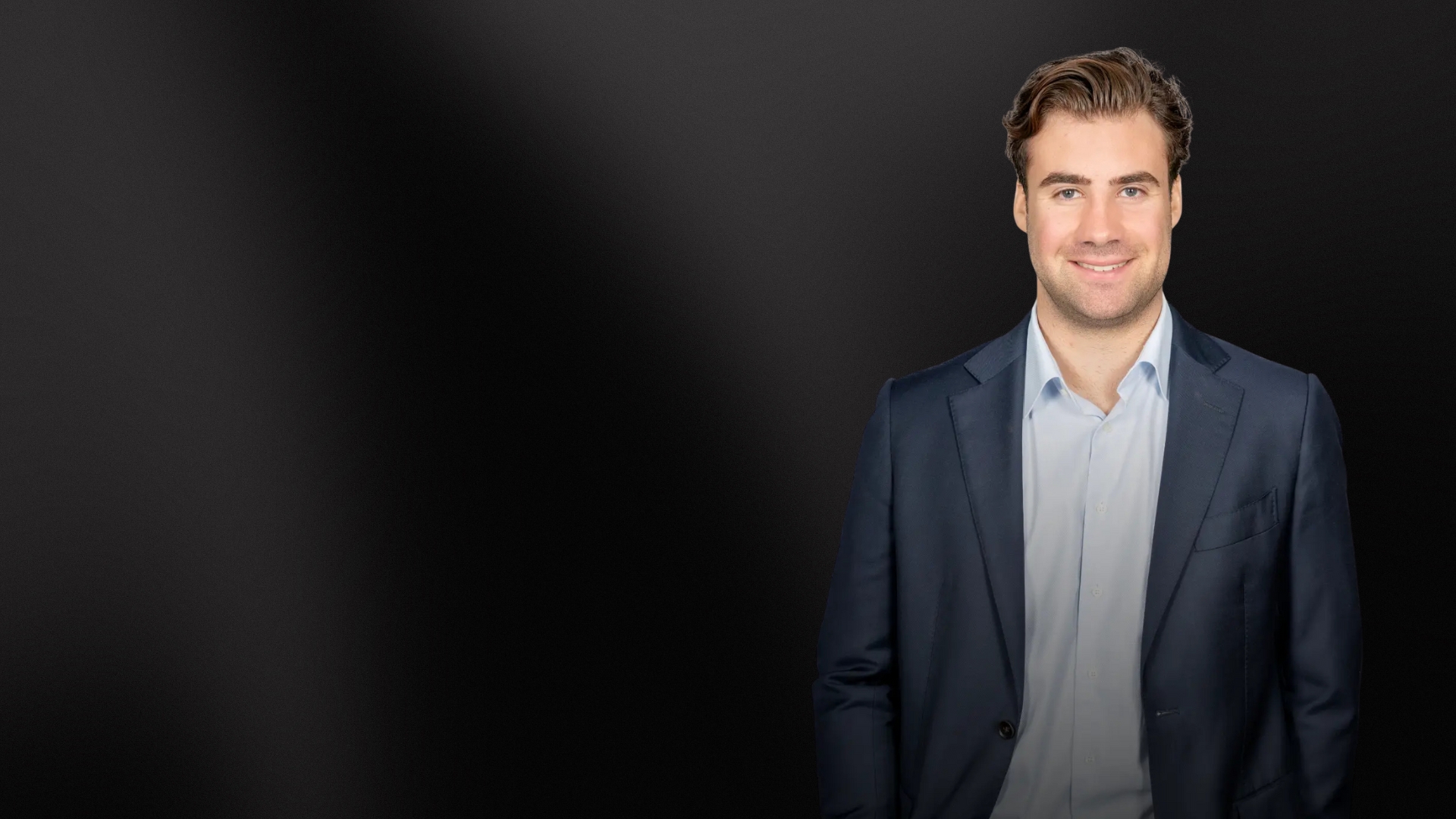 Portrait eines Immobilienexperten vor dunklem Hintergrund