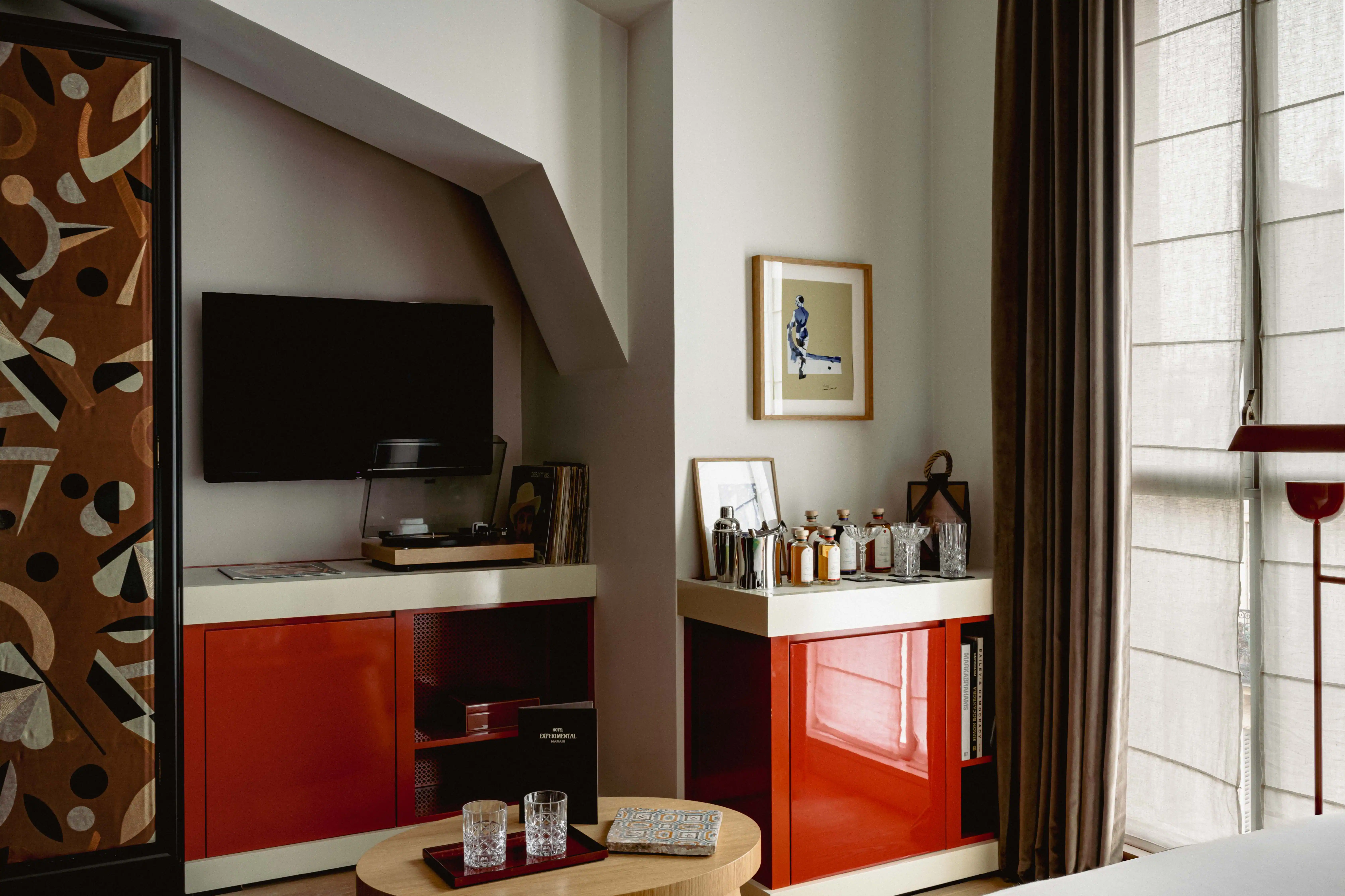 Elegant room at Experimental Marais featuring a discreetly integrated television.