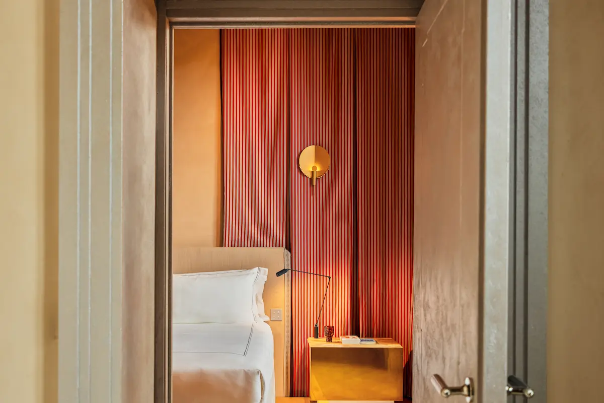 Guest room view at Experimental Roma with a bed and bedside table.