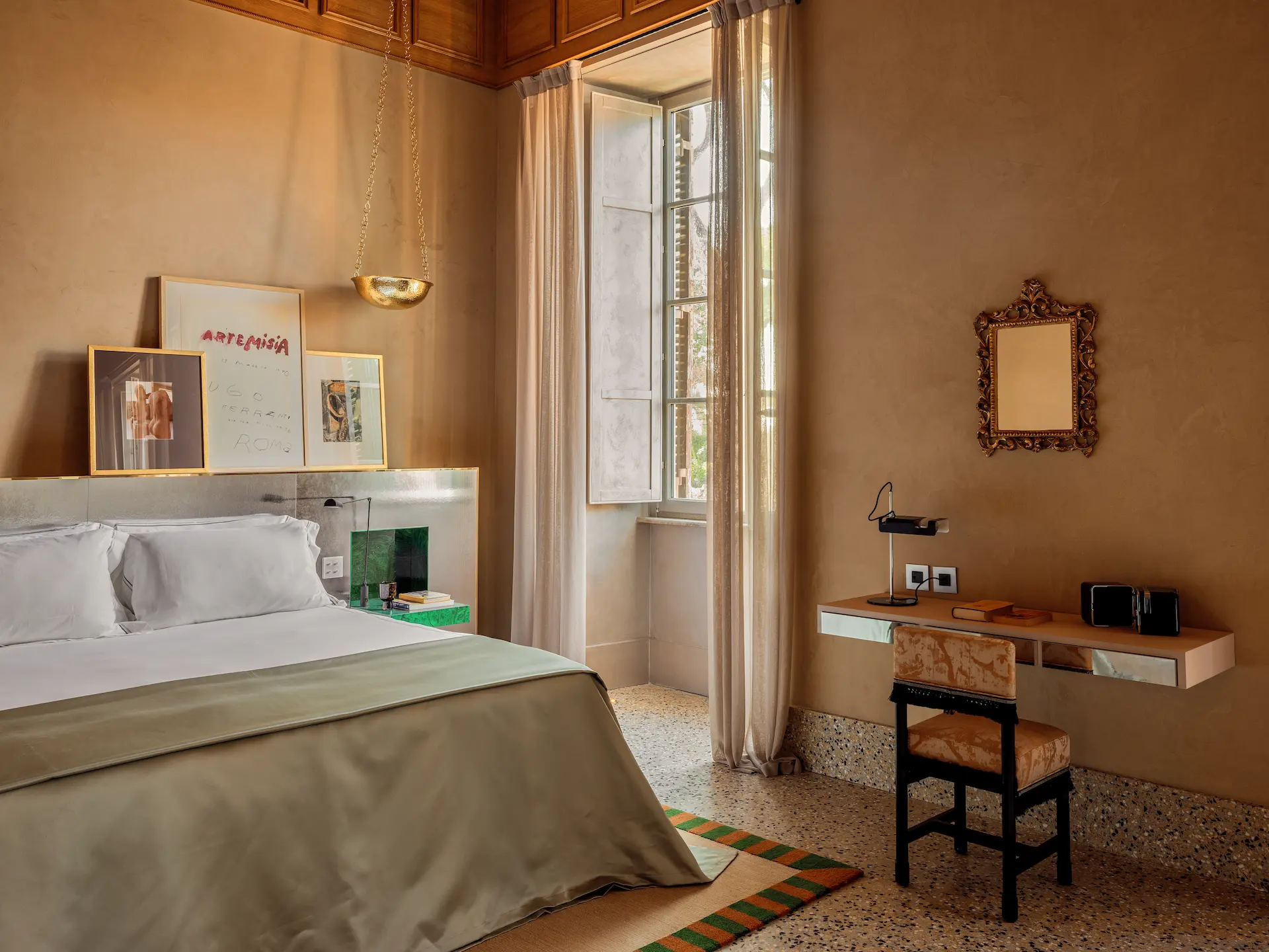 Suite interior at Experimental Roma with double bed, desk and decorative details.