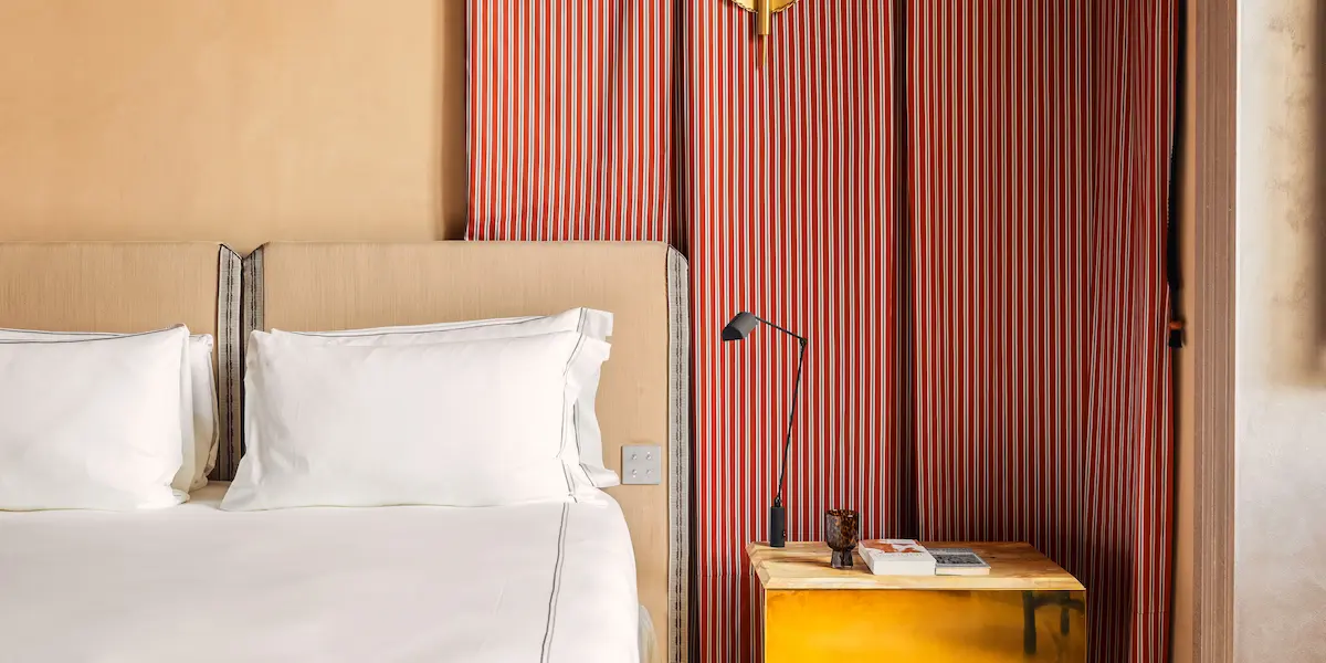 Bathroom interior at Experimental Roma with vanity, towels and soft lighting.
