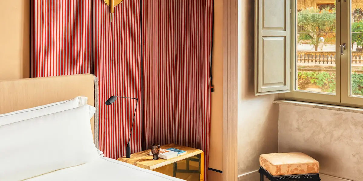 Guest room interior at Experimental Roma with a double bed and bench seating.