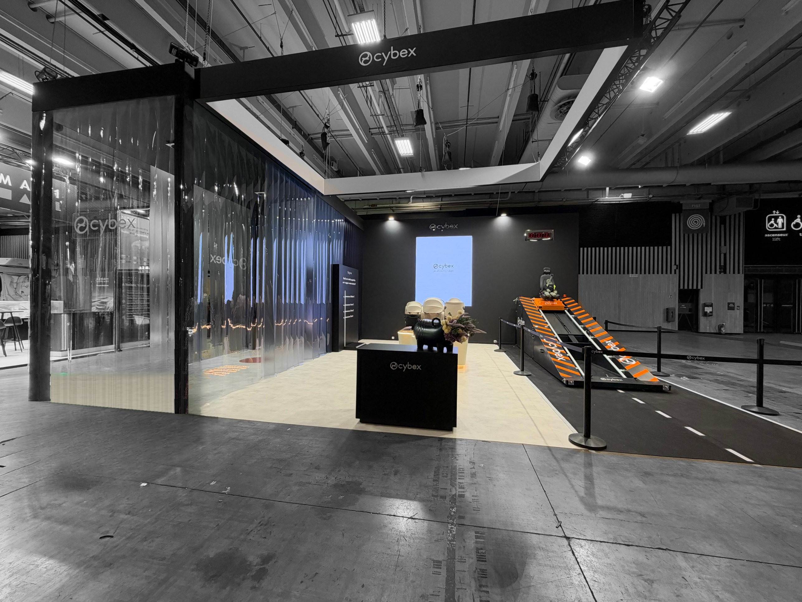 Stand immersif Cybex au Mondial de l'Auto 2026 – rampe de crash test et façade en lanières de bâche cristal