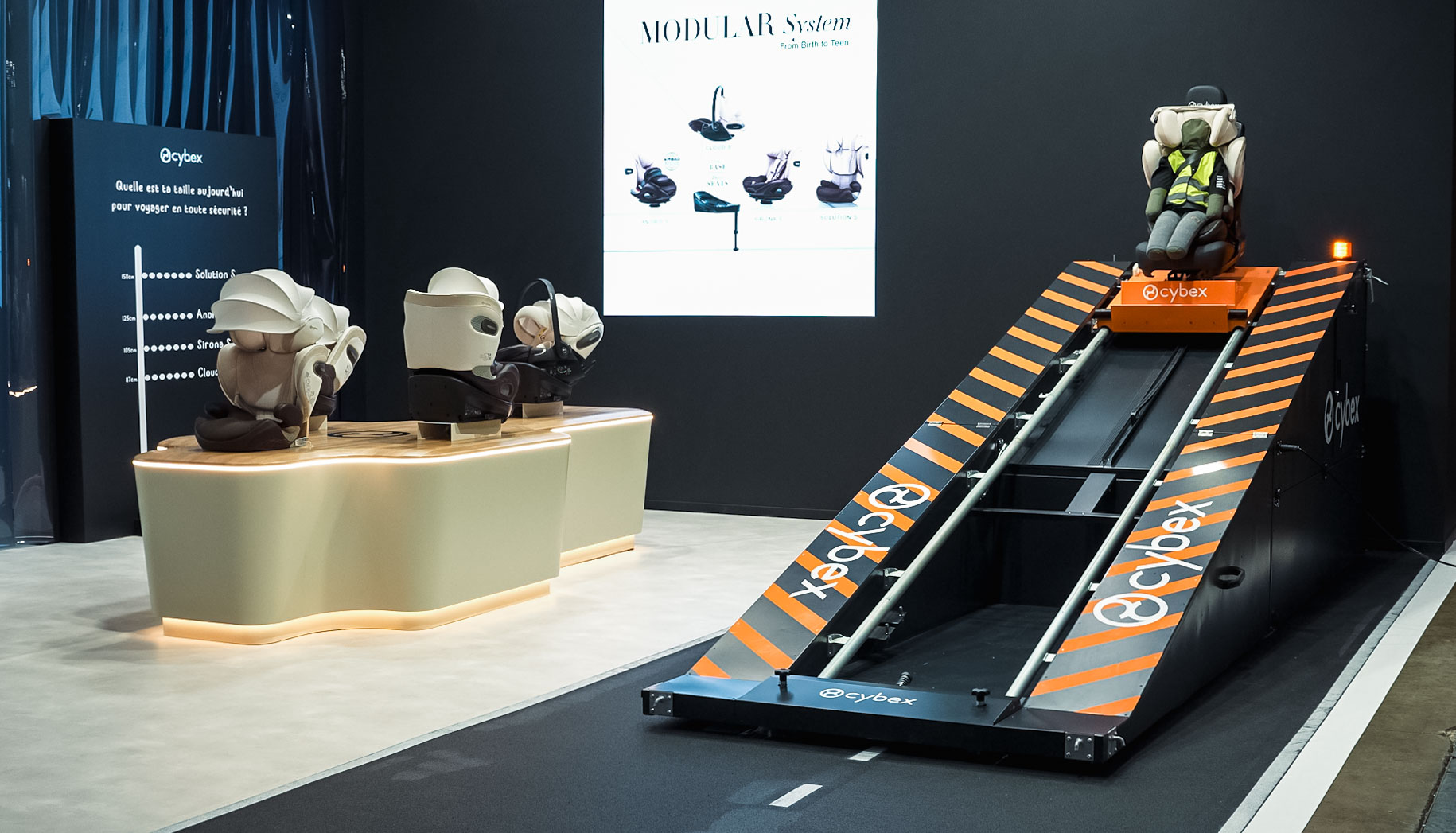 Rampe de crash test et présentoir de sièges auto sur le stand Cybex du Mondial de l'Auto 2026