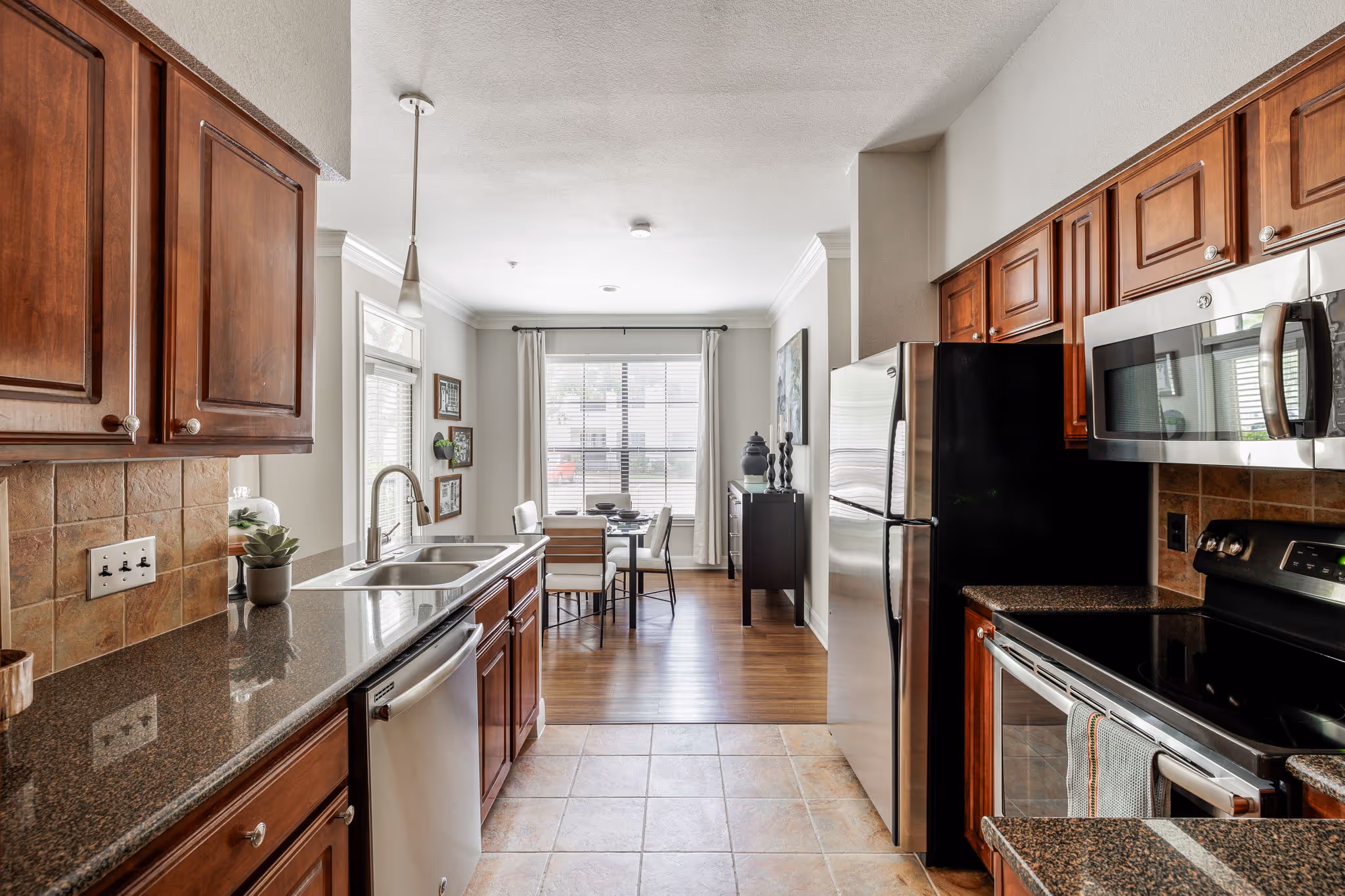kitchen with stainless steel appliances with view into dining room with chairs and tables