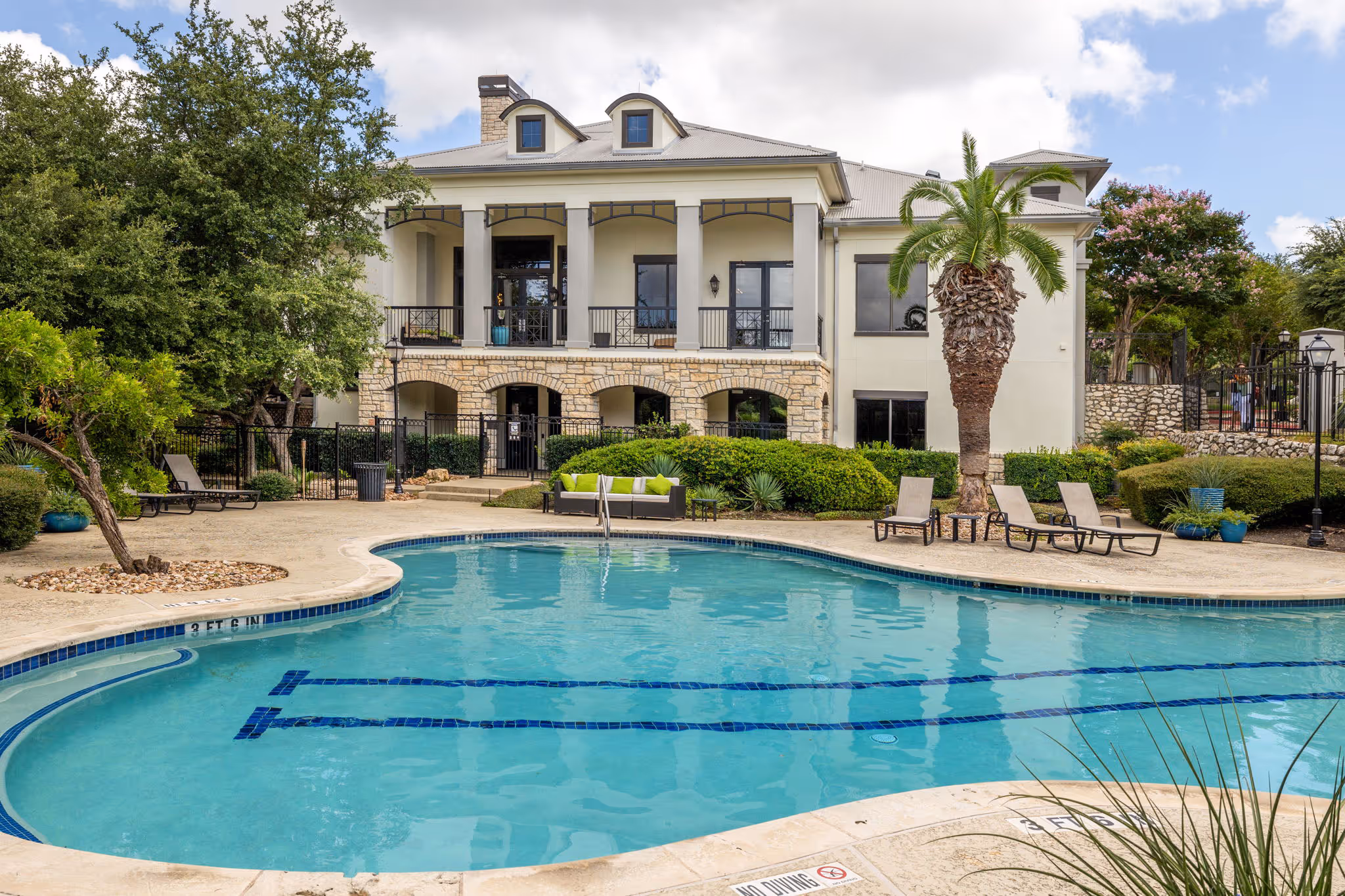 swimming pool with trees and lounge chairs