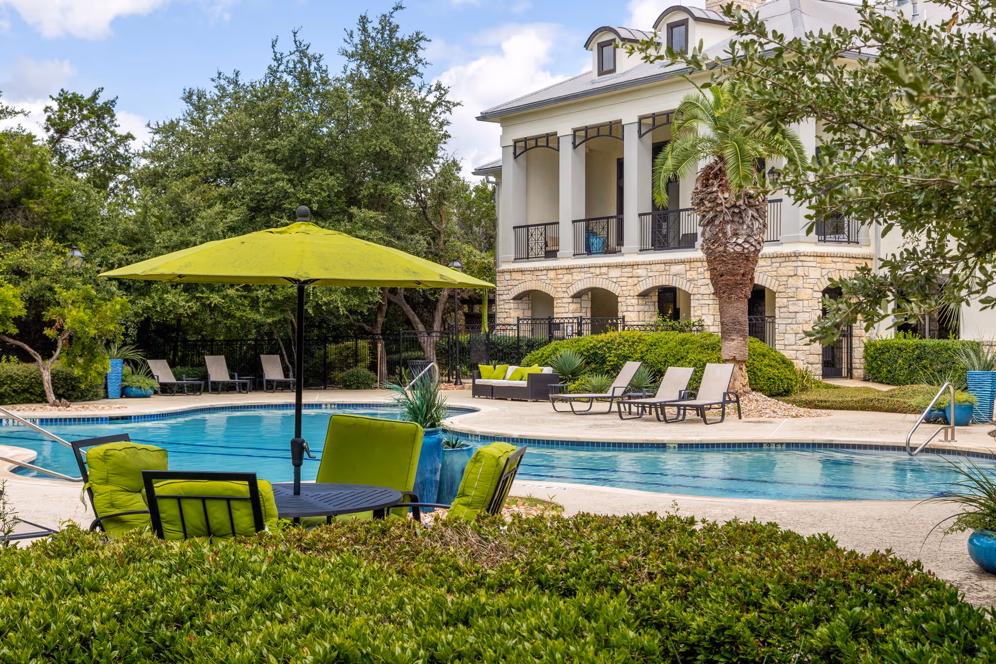 view of swimming pool with lounge chairs and chairs with umbrellas
