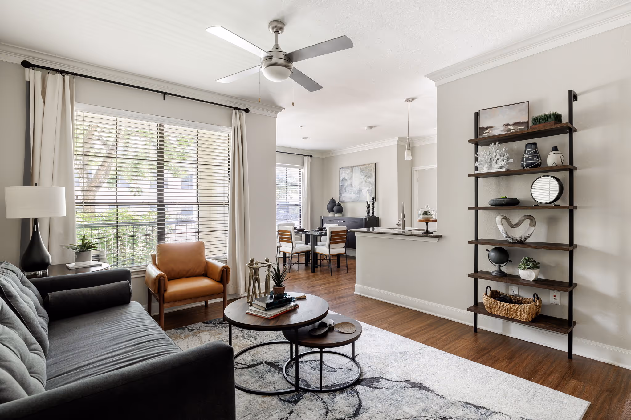 Living area with sofa, book shelf and coffee table and view of balcony