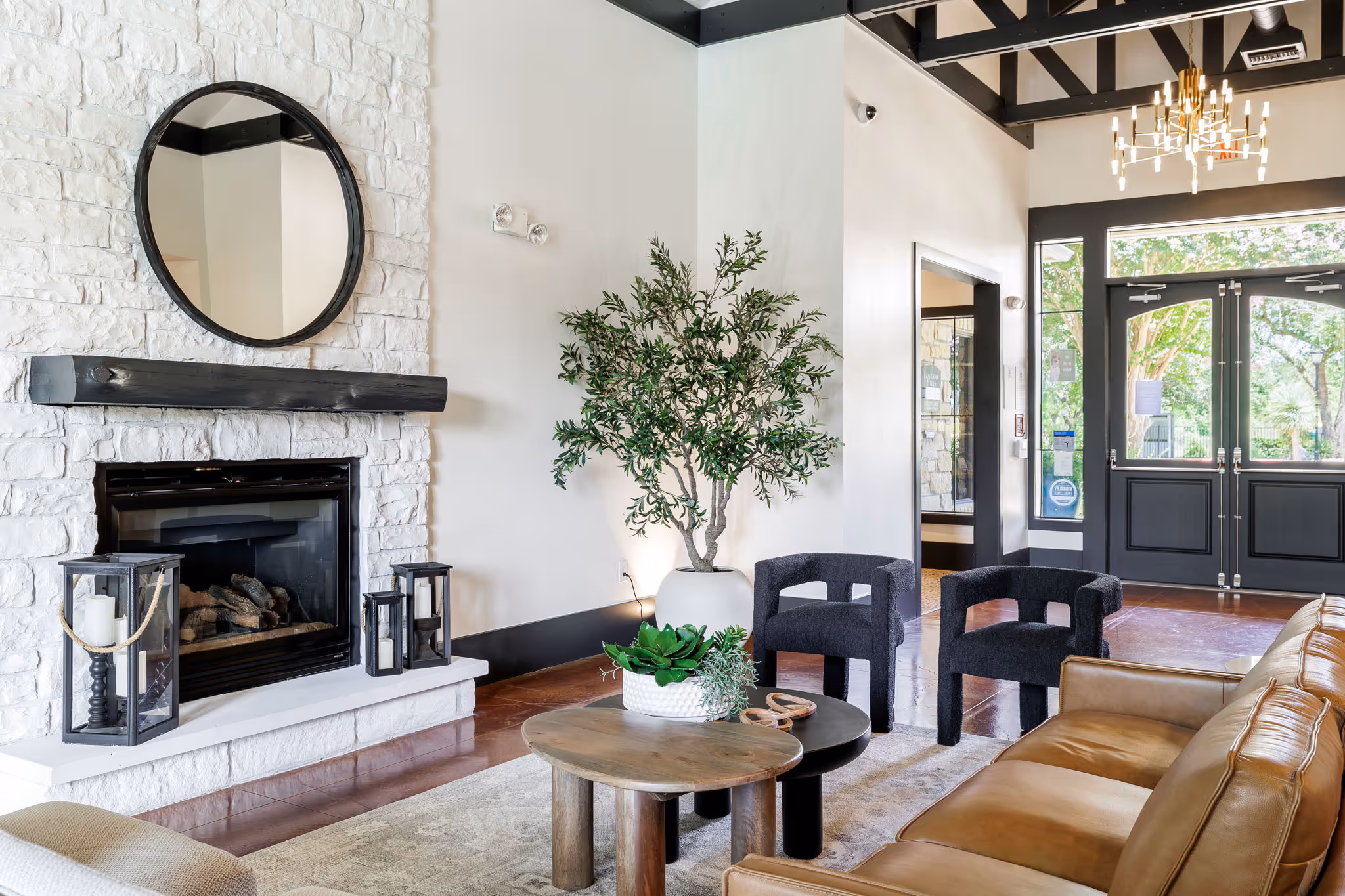 Clubhouse lounge are with plants, fireplace, chairs, and tables with decor