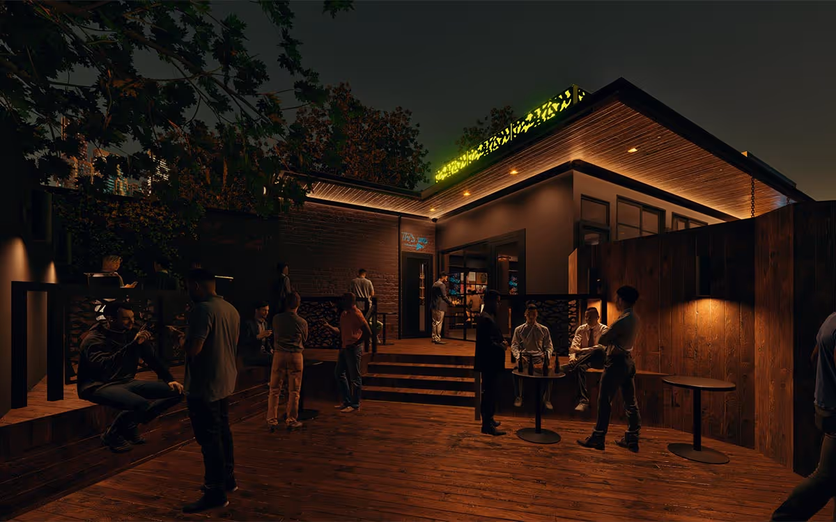Sunny porch with two metal mesh chairs, stone half-wall, and metal railing overlooking green trees.