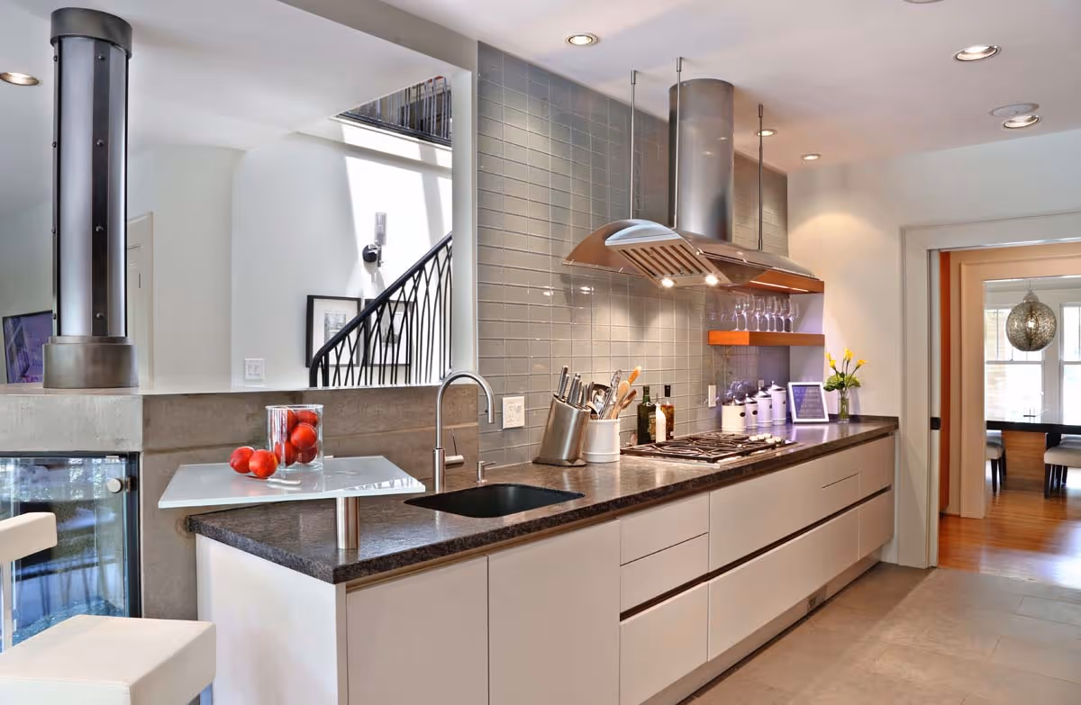 Bright living room featuring a large potted plant in front of a stone fireplace, with a painting above and modern seating areas visible.