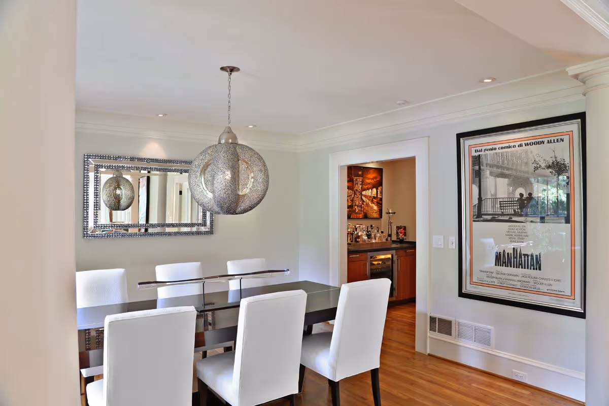 Modern bathroom with double sinks, large mirrors, and a view into a walk-in closet with clothes and shelves.