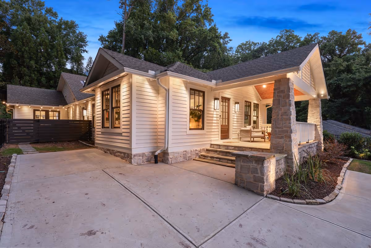Luxurious wine cellar with wooden racks filled with wine bottles, a wooden island with decanters and a wine bottle, and a large modern chandelier above.