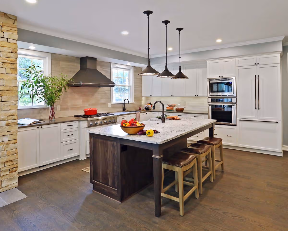 Modern bathroom sink with a white bowl basin, chrome faucet, a vase of red flowers on a brown marble countertop, and colorful artwork featuring kids with bandanas on the wall.