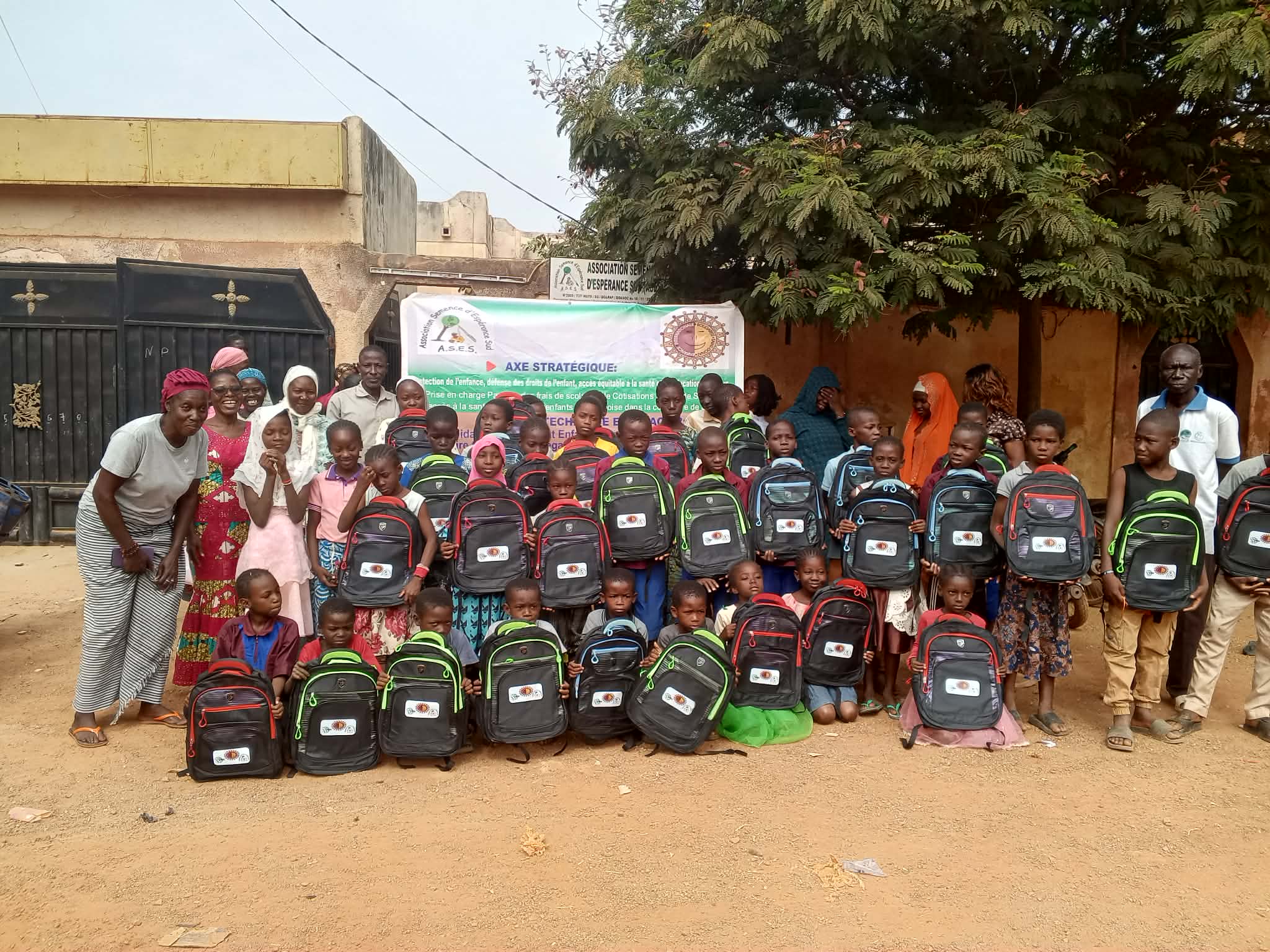 Classe d'enfants du Burkina Faso tenant chacun un nouveau sac à dos