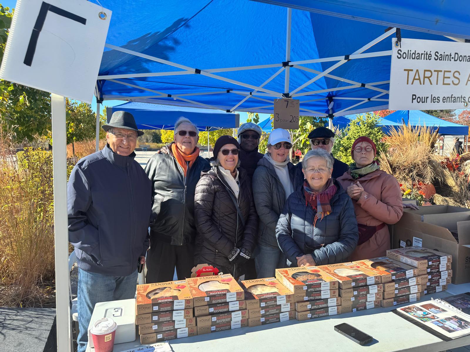 Groupe de personnes devant un stand de tartes