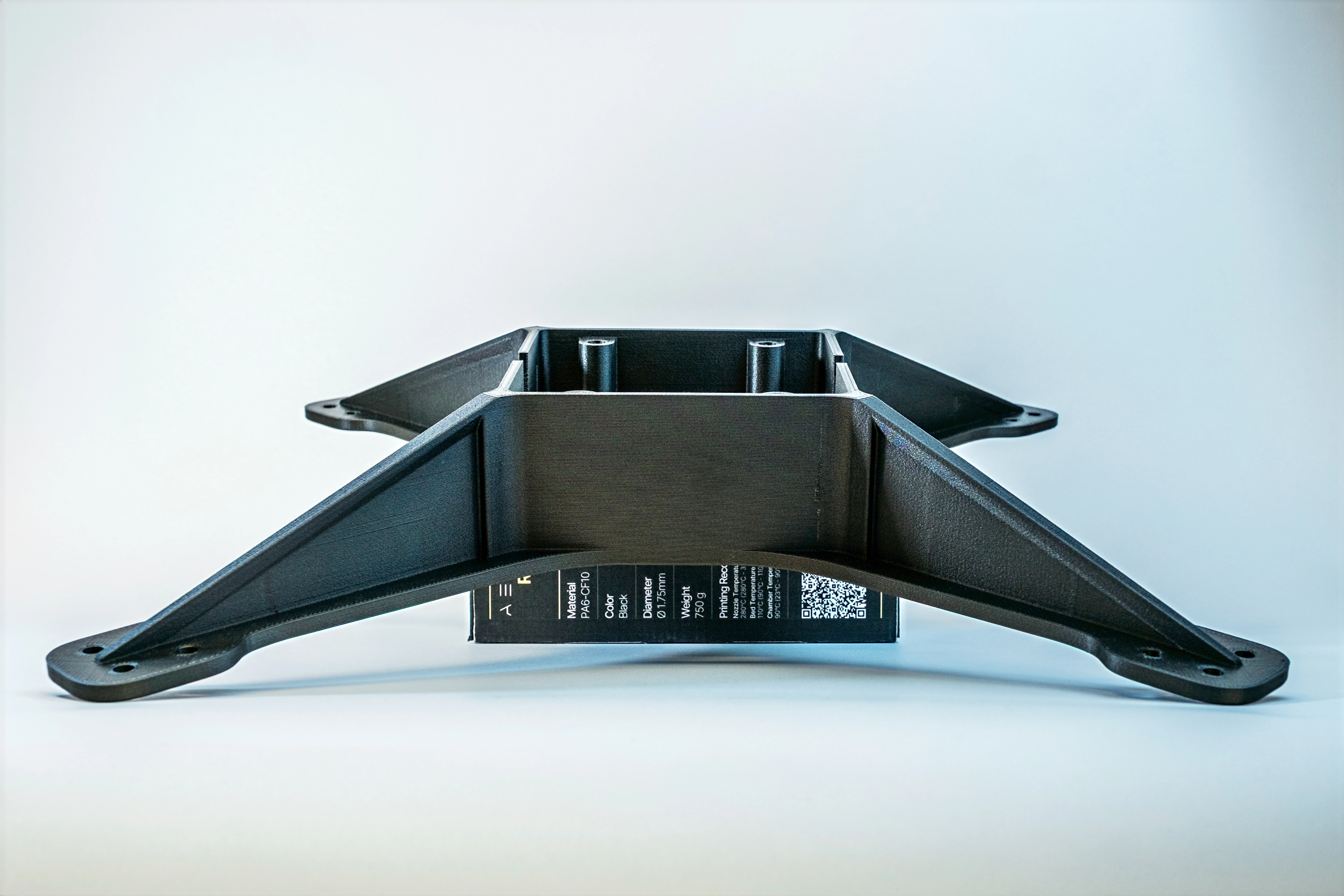 Close-up of a perforated metallic surface with orange and blue light reflections.