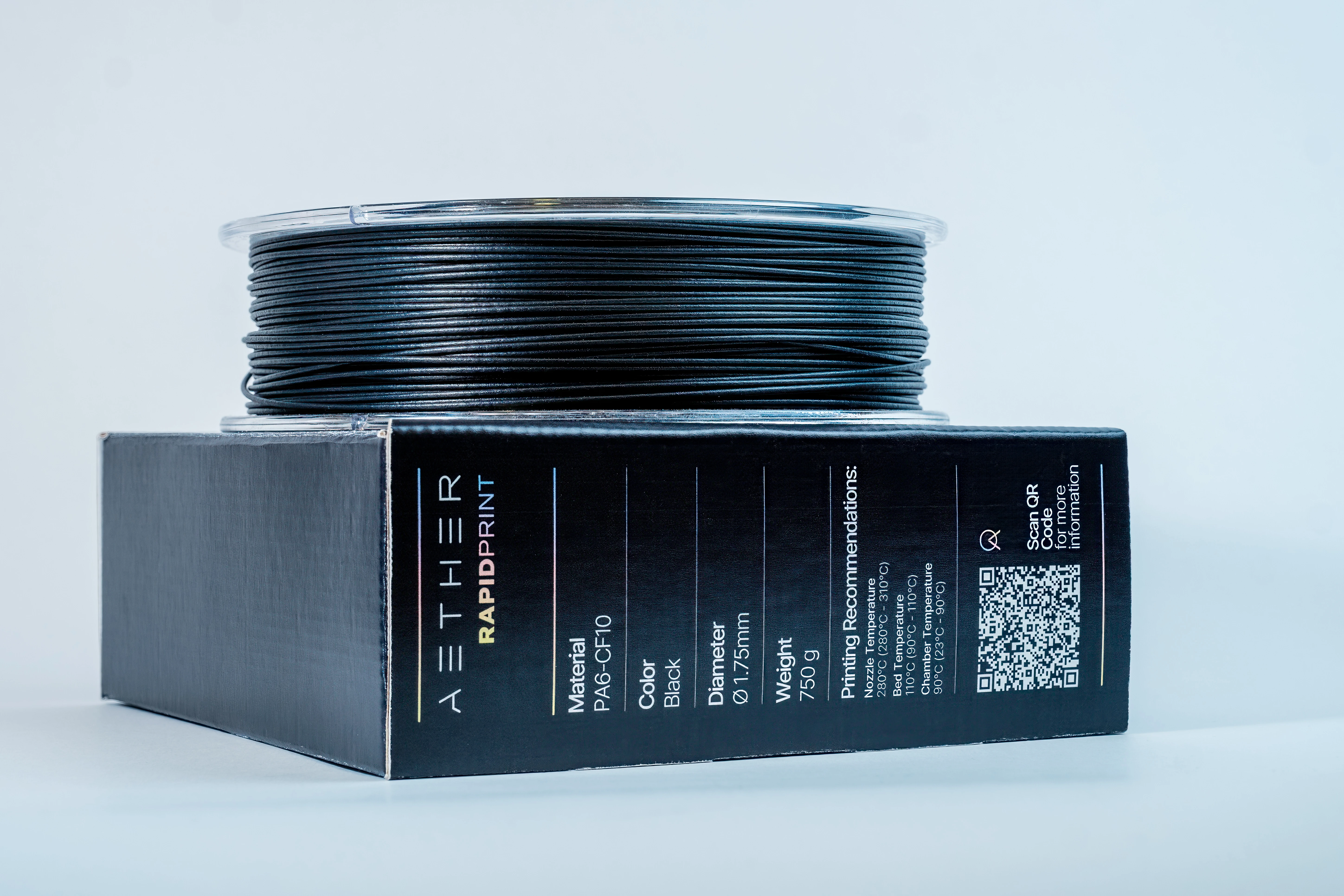 Spool of black 3D printer filament on a box labeled AETHER RAPIDPRINT with material and printing specifications.