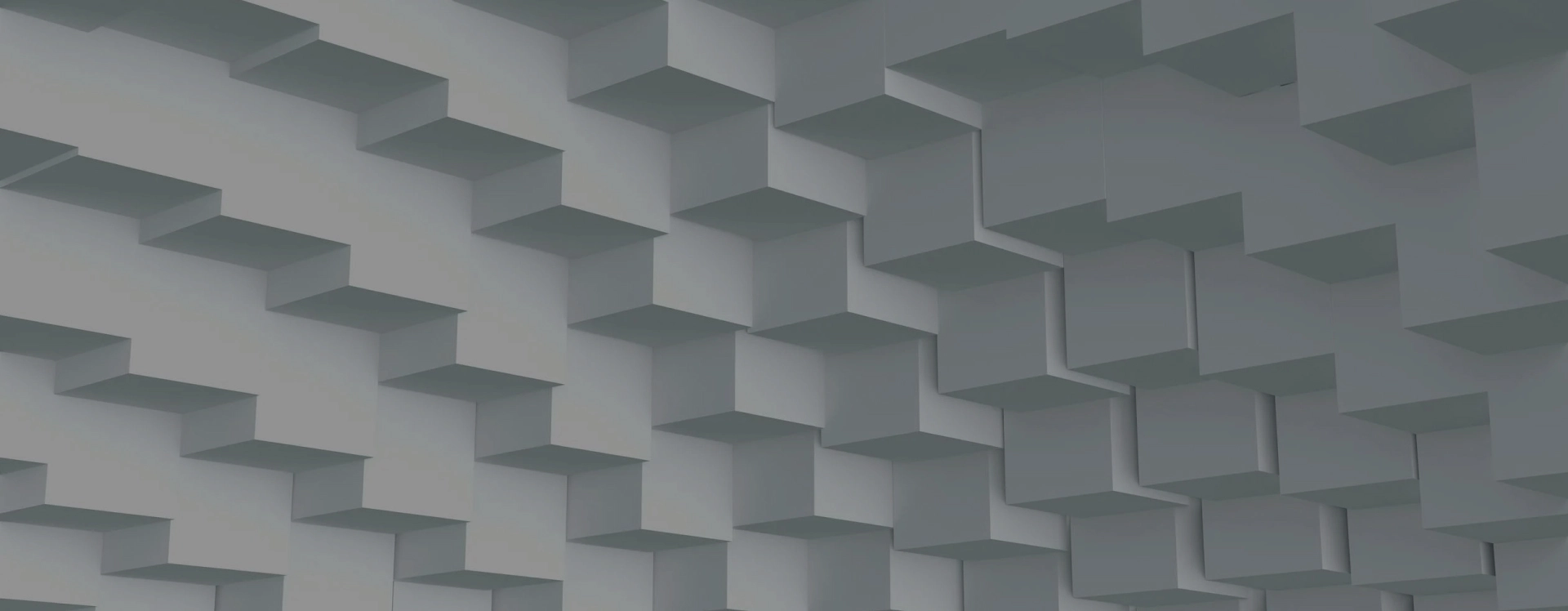 Three-dimensional geometric pattern of interlocking gray rectangular blocks creating a textured wall surface.