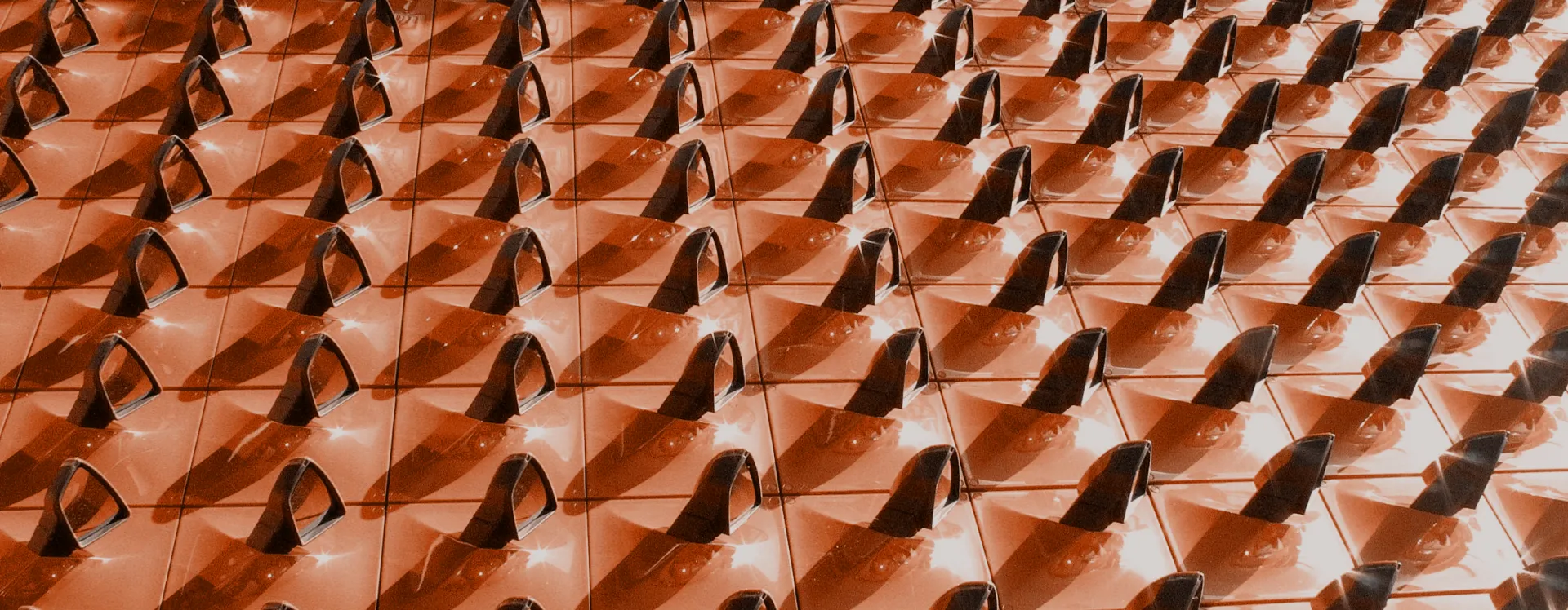 Rows of solar panels angled to capture sunlight, casting shadows in a geometric pattern.