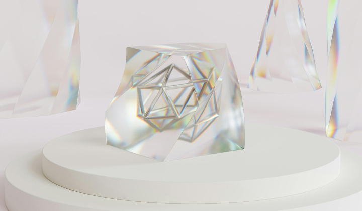 Transparent prism with geometric metal framework inside, placed on a white round pedestal with additional prisms suspended around it.