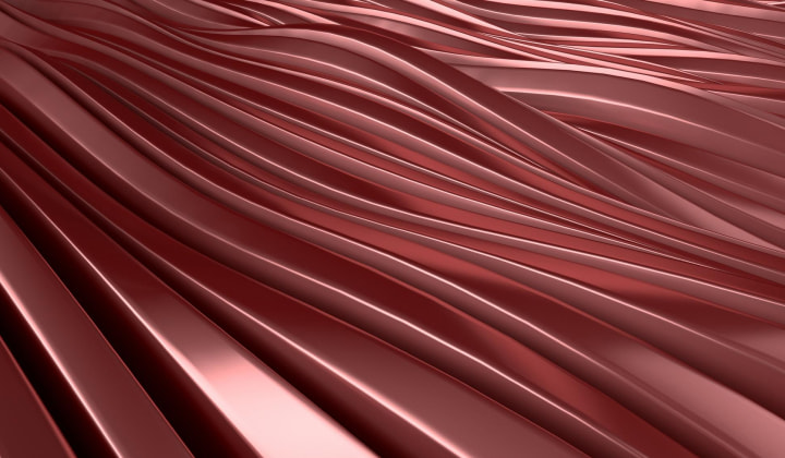 Person in white clothing holding a credit card and typing on a silver MacBook laptop on their lap.