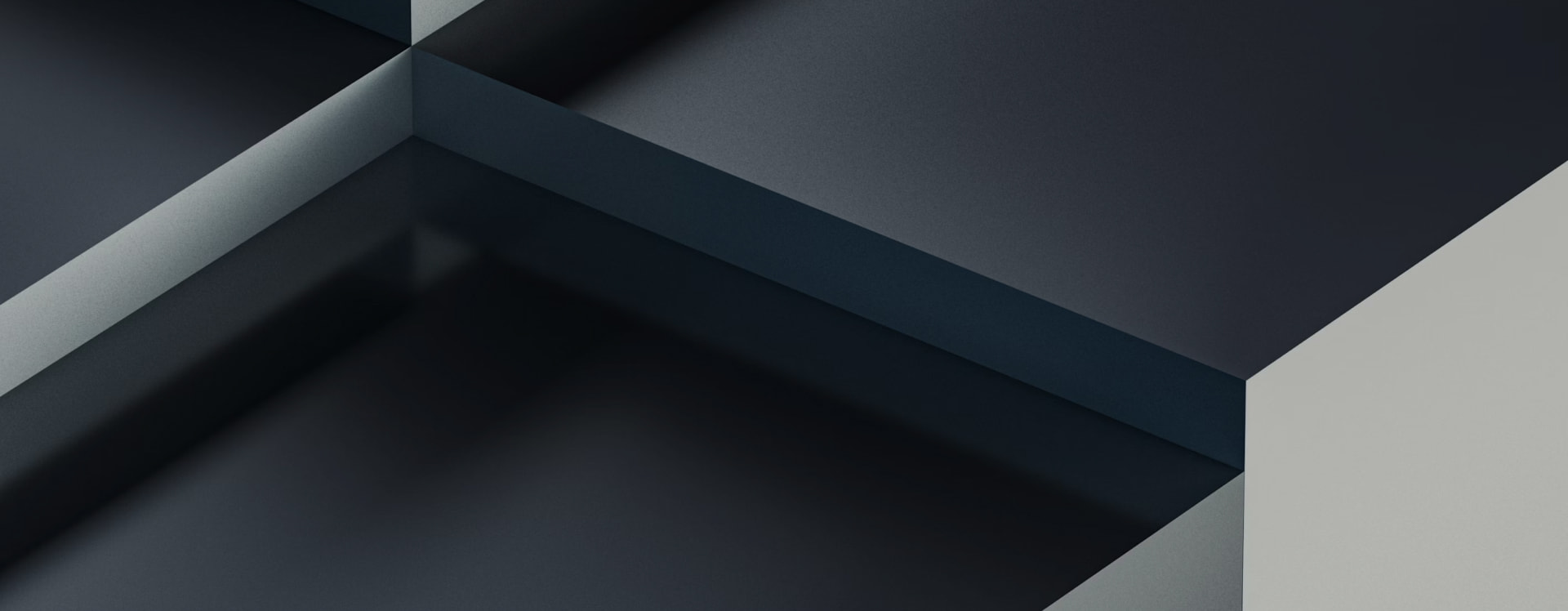 Close-up of interlocking dark gray geometric blocks forming an abstract pattern.