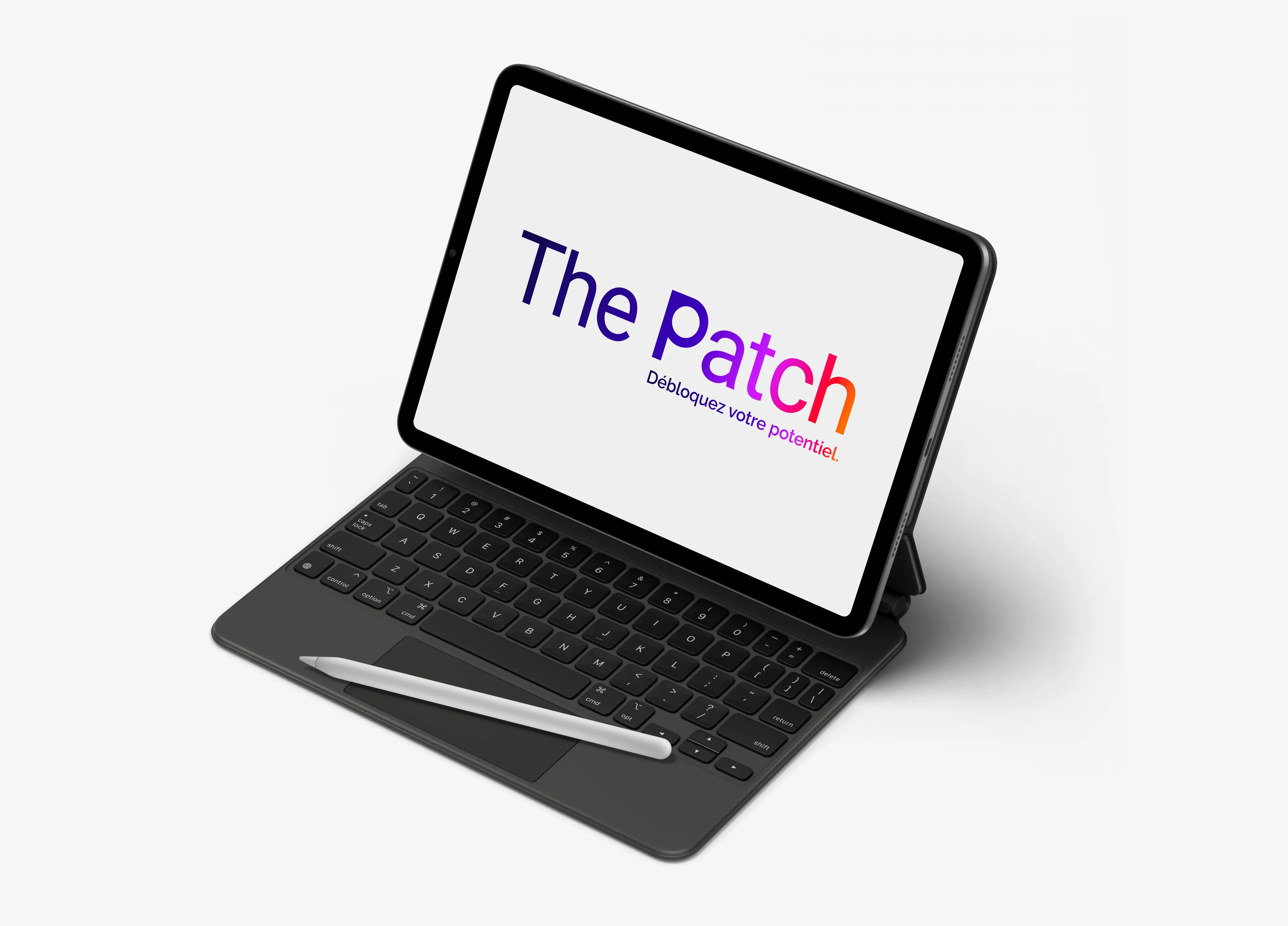 Tablette avec clavier noir et stylet posé, affichant le texte coloré « The Patch Débloquez votre potentiel » sur fond blanc.