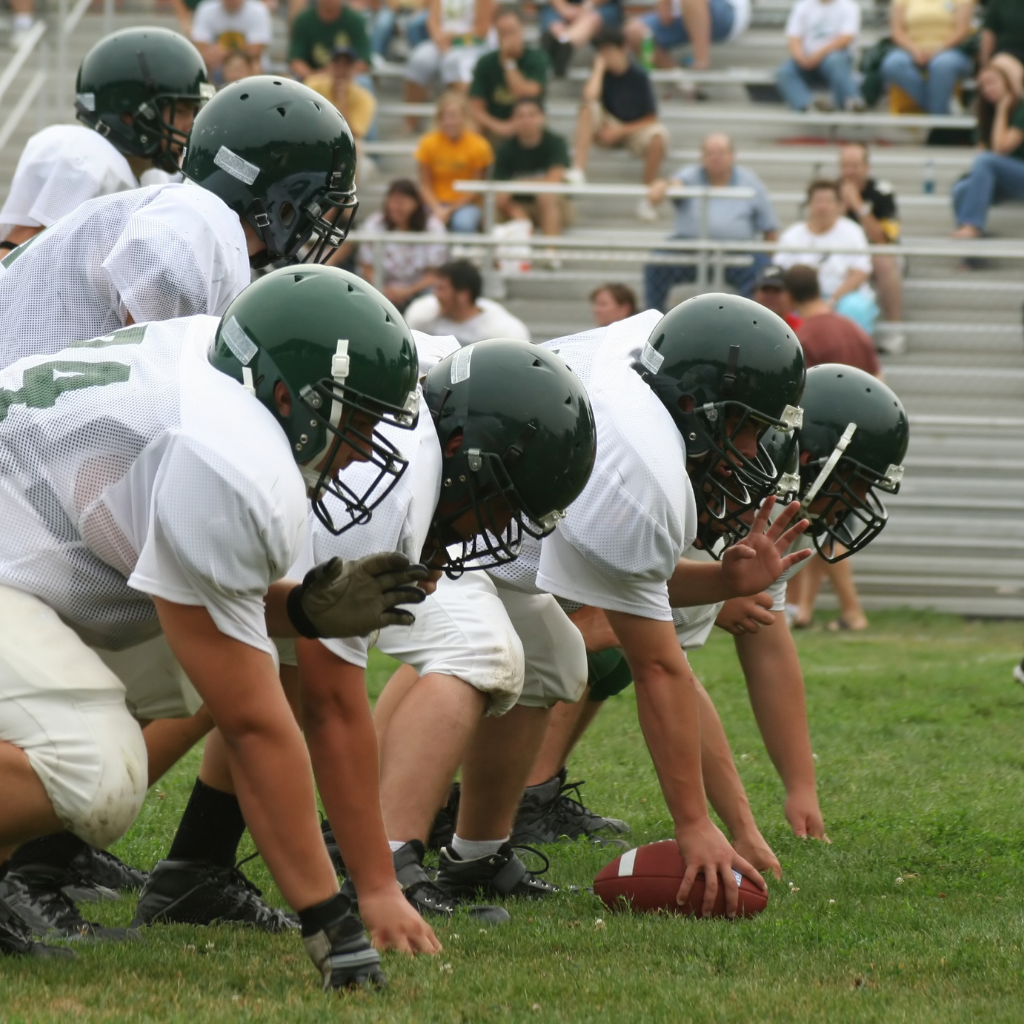 High school football players in full pads in the heat.