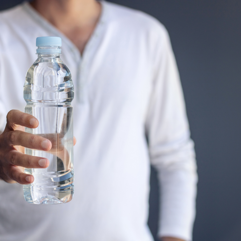 Person holding a bottle of water emphasizing the importance of hydration.