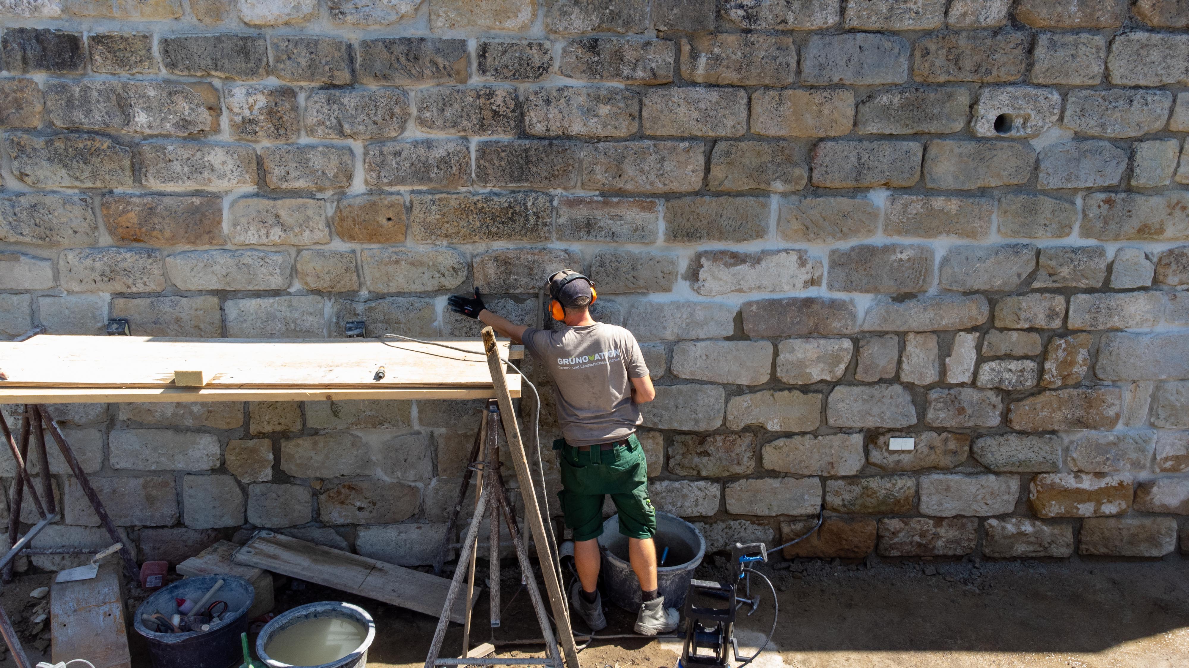 Ein Mitarbeiter beim Sanieren einer Wand.