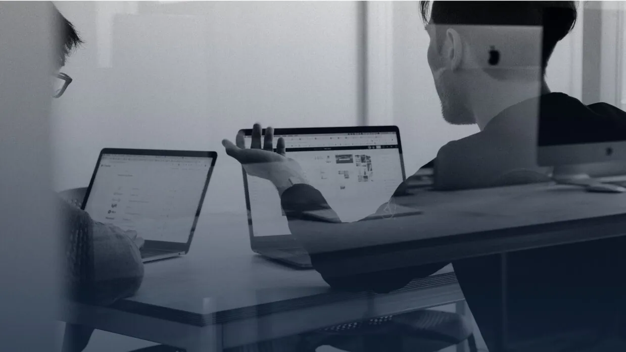 Two people reviewing a website on their laptops
