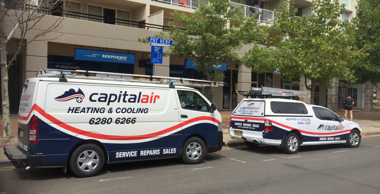 Capital Air heating and cooling service vehicles parked on a Canberra street outside local shops.
