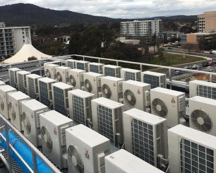 Commercial HVAC outdoor units installed on a rooftop with city views.