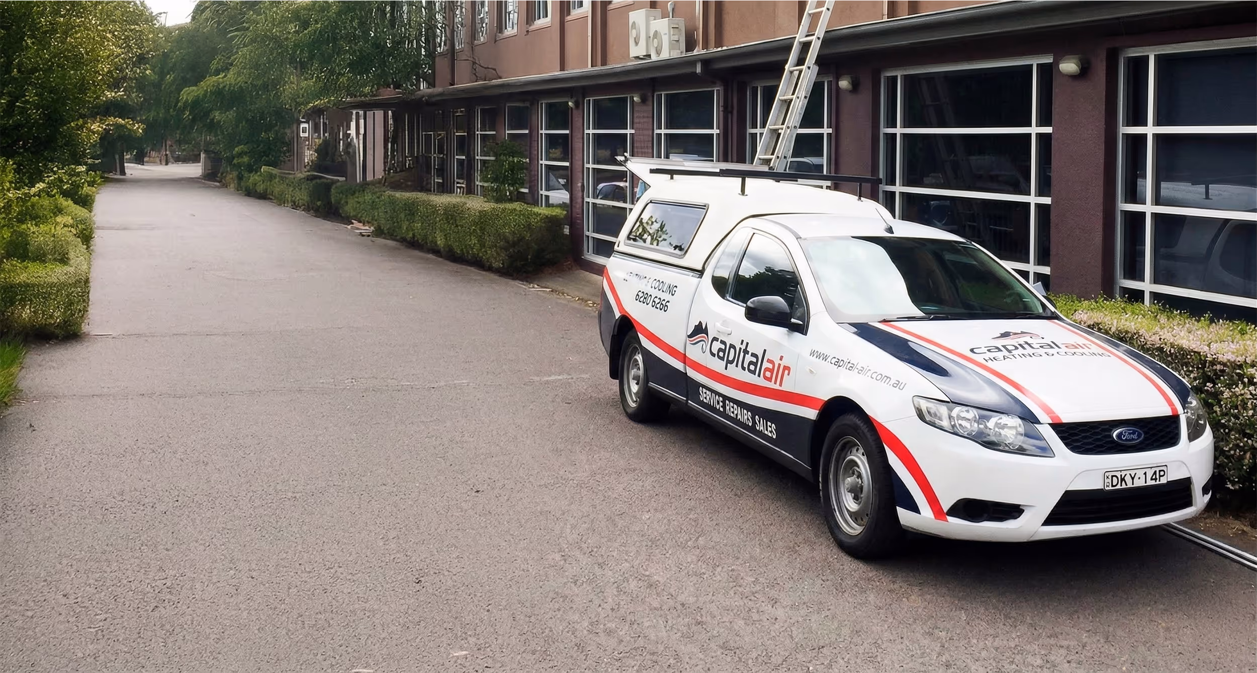 Capital Air Group repairing an air conditioner in a townhouse complex.