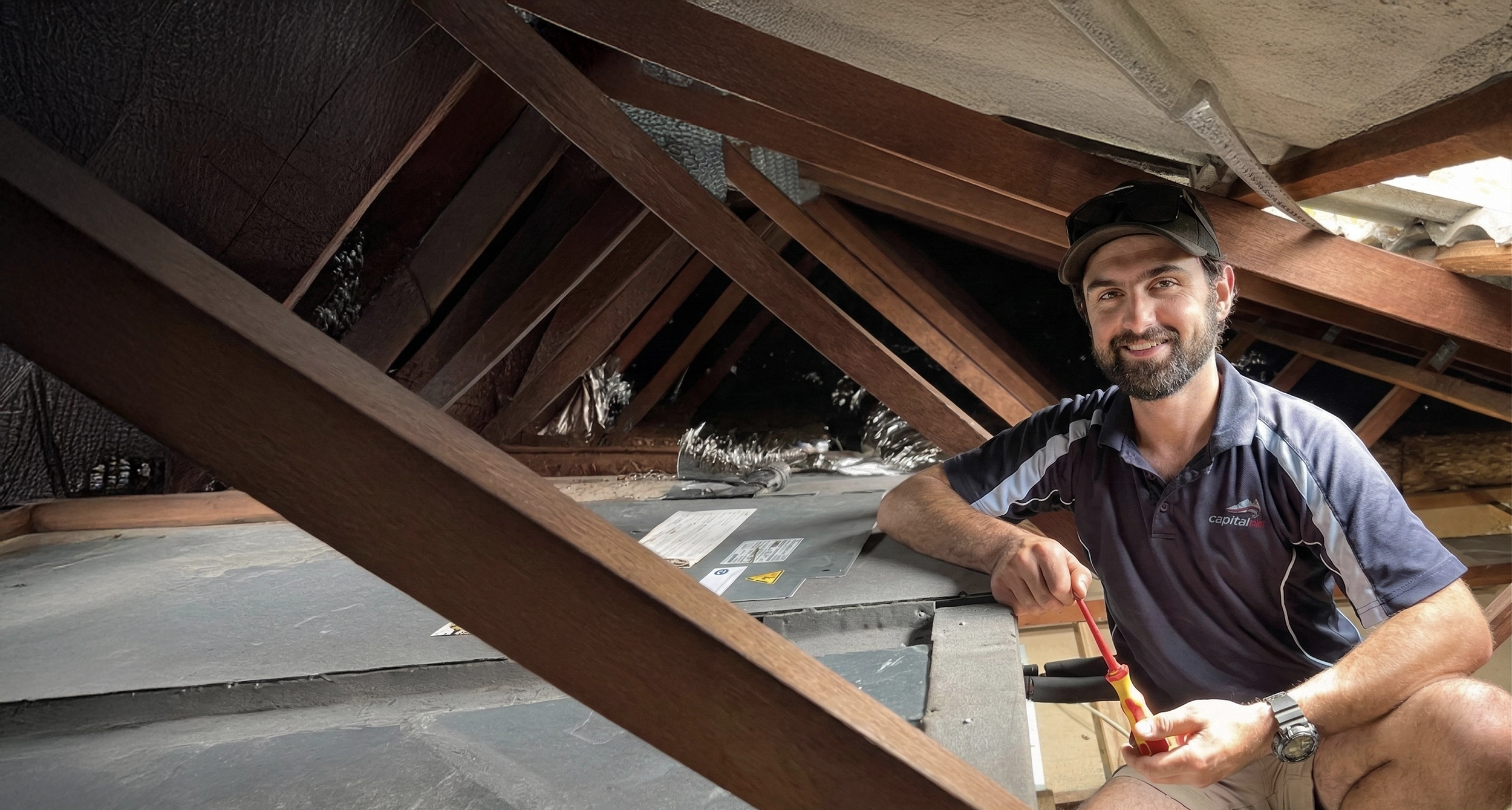 Capital Air heating and cooling service vehicles parked on a Canberra street outside local shops.