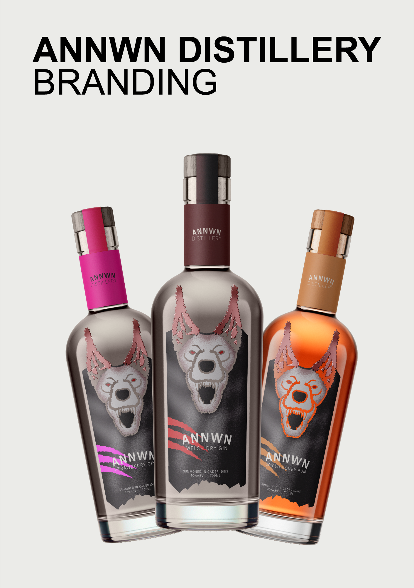 Three Annwn Distillery bottles with fierce dog logo: strawberry gin with a pink label, Welsh dry gin with a dark label, and spiced honey rum with an orange label.