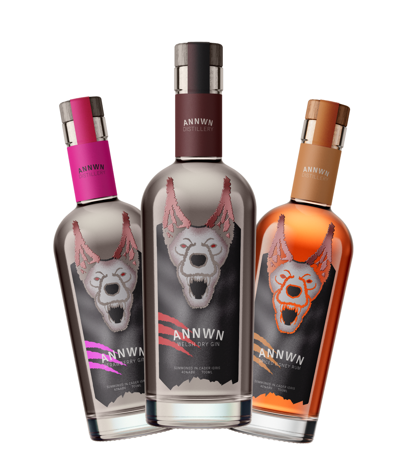 Three ANNWN Distillery bottles with wolf head labels: Strawberry Gin with pink cap, Welsh Dry Gin with brown cap, and Spiced Honey Rum with orange cap.