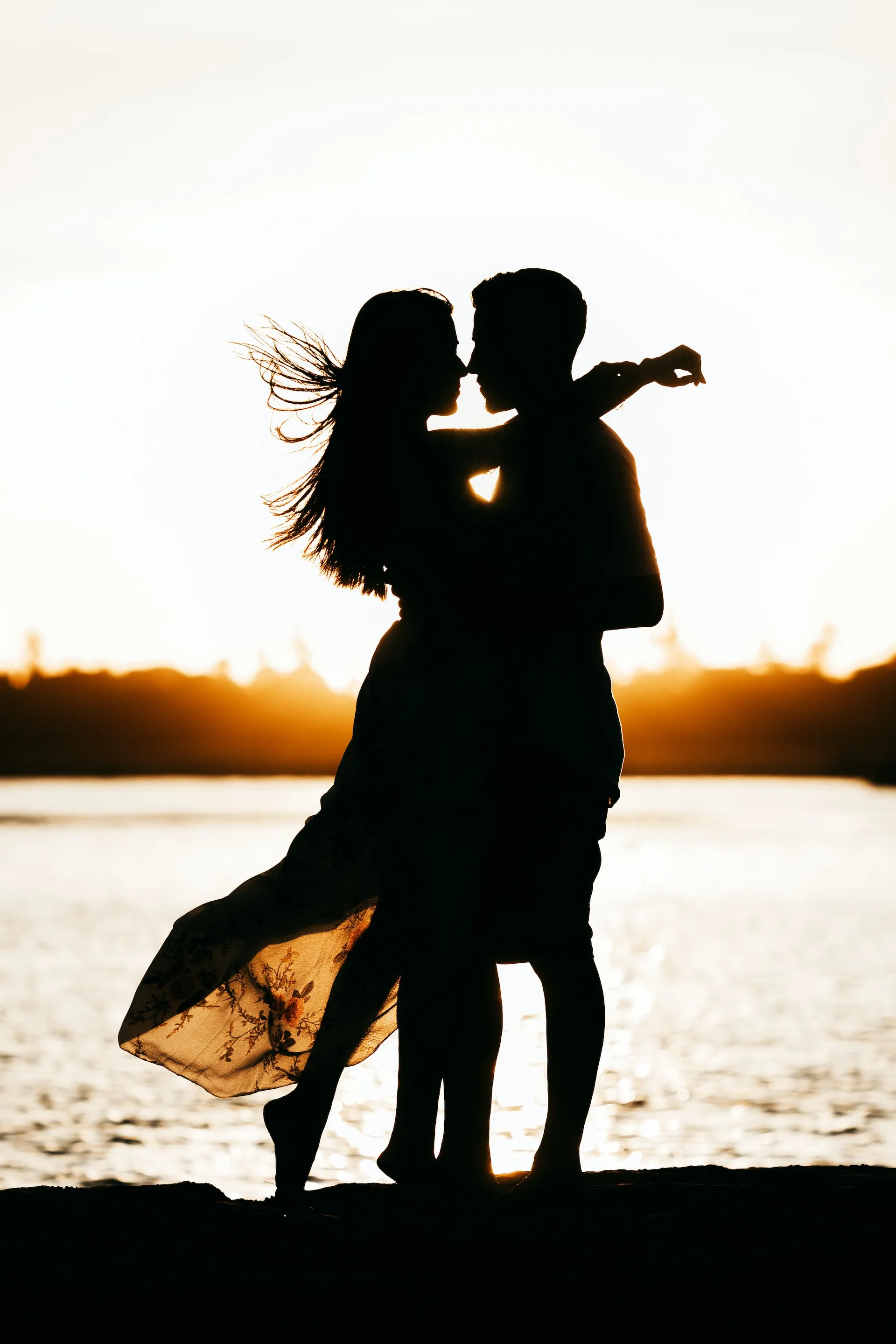 A young couple hugging each other on the beach