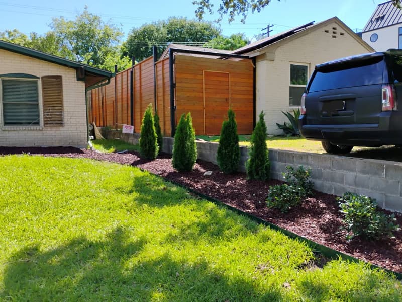 Well-maintained front yard with drought-tolerant plants, a curved walkway, and trimmed hedges.