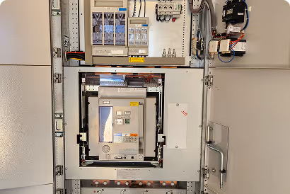 Geöffneter elektrischer Schaltschrank mit Schaltgerät und verdrahteten Komponenten.