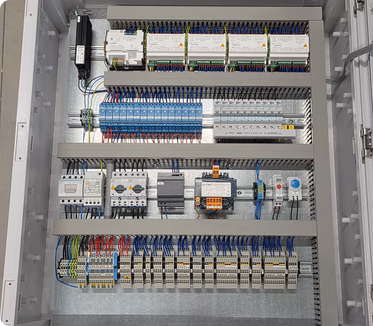 Geordnetes elektrisches Steuerungspanel mit Reihen von Relais, Schutzschaltern, Verdrahtungen und Steuergeräten in einem Metallgehäuse.