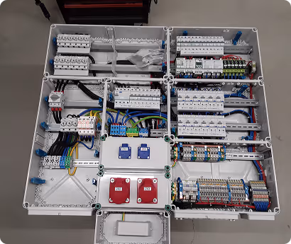 Offene elektrische Verteilerbox mit geordneten Sicherungen, Relais und farbigen Kabeln.