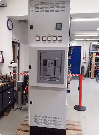 Großer elektrischer Schaltschrank mit Schaltern und Steuergerät in einer Werkstatt.